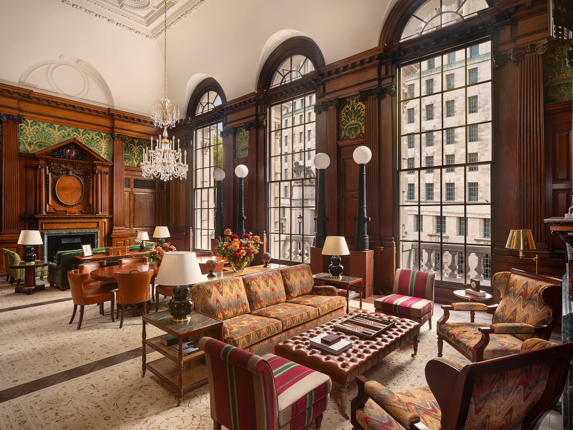 Panelled hotel hall with tall windows and a stone stair to one side