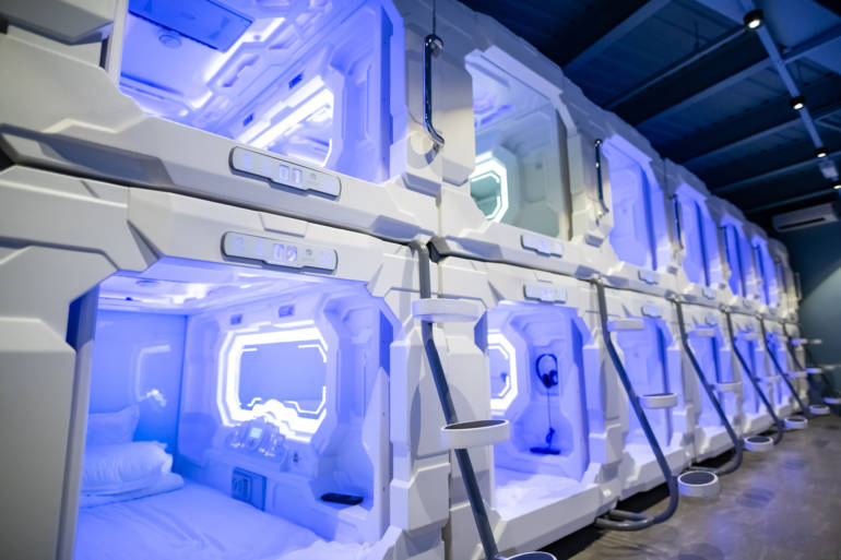 Two tiers of moulded sleeping berths along a lit corridor