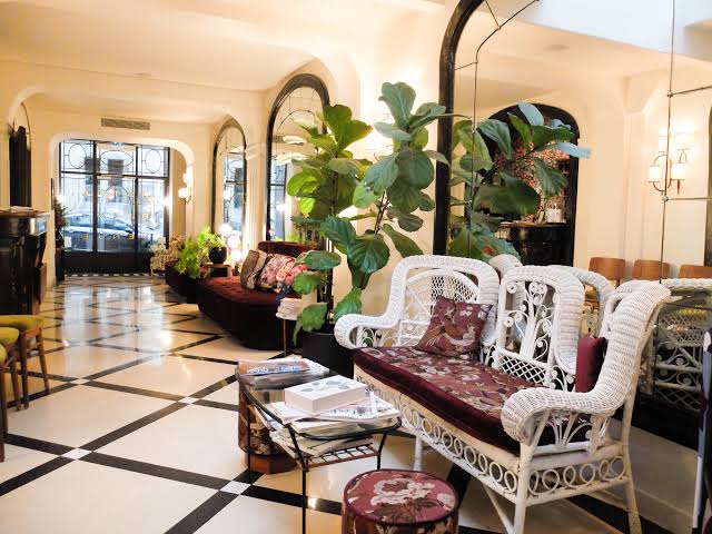 Panelled sitting room with patterned upholstery, a low table and a tall window