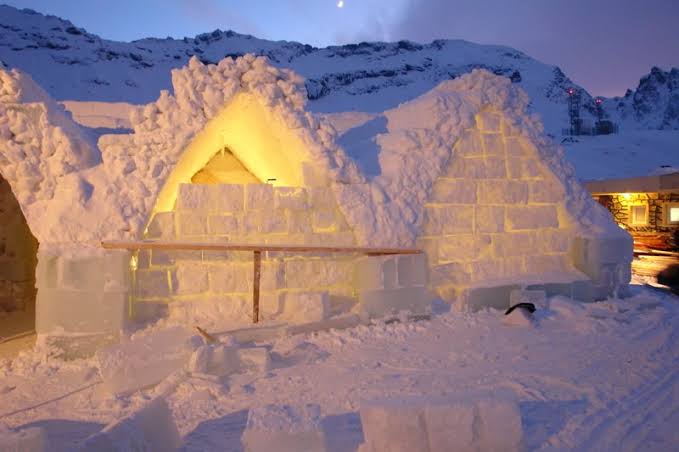 Rounded structures of packed snow on a mountain shelf under overcast light